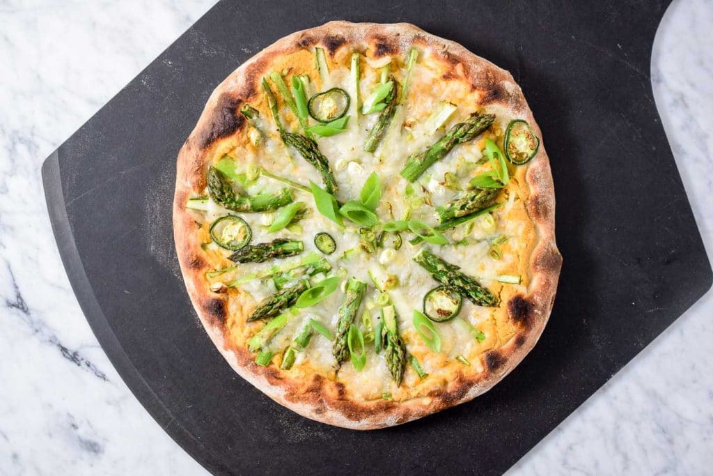 vegan asparagus pizza with a spicy chickpea sauce