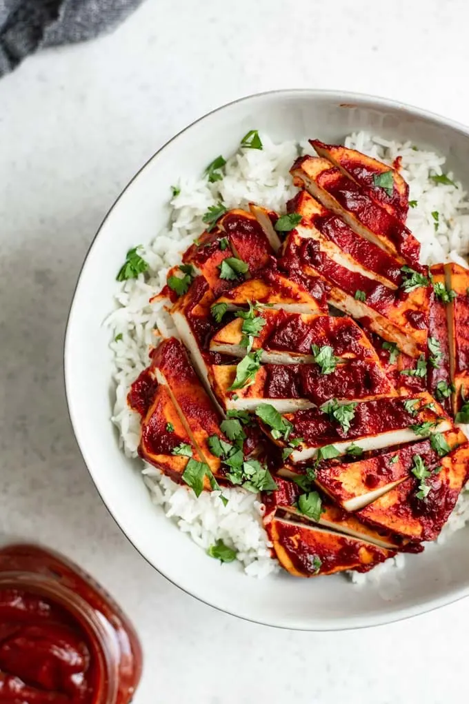 close up of the chipotle barbecue baked tofu with additional barbecue sauce on the side