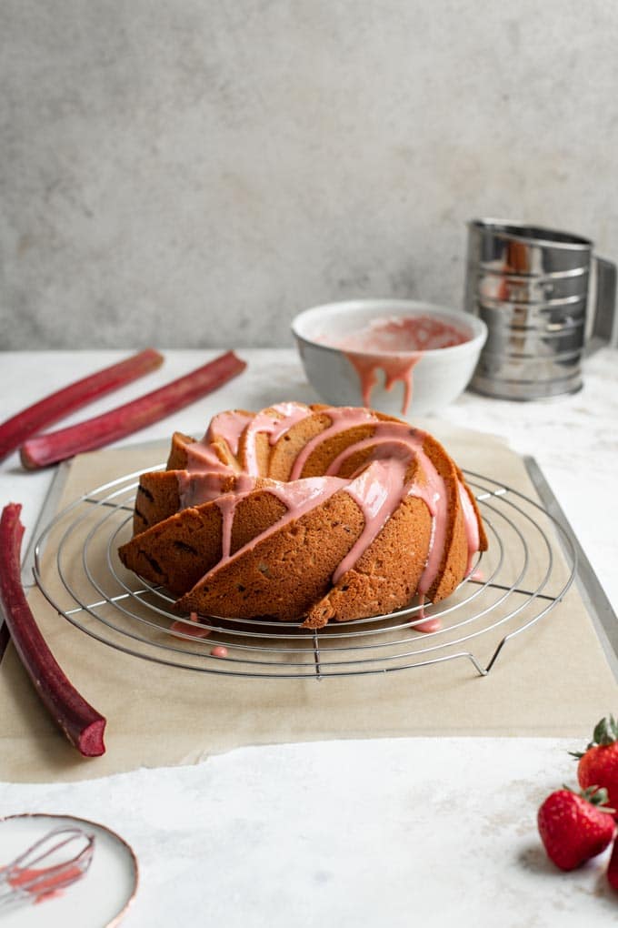 a freshly glazed cake set on a wire rack over a parchment lined baking tray for easy clean up