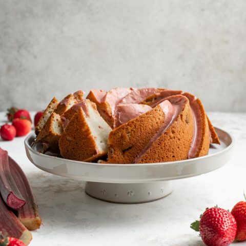 straight on shot of the almond rhubarb bundt cake with some slices cut and set at an angle so you can see the soft texture