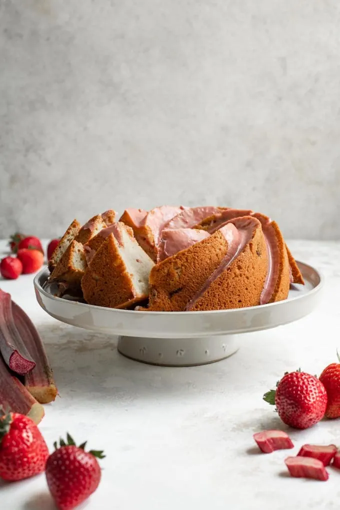 straight on shot of the almond rhubarb bundt cake with some slices cut and set at an angle so you can see the soft texture