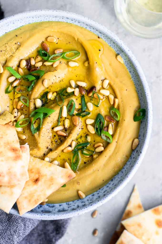 closeup of favosalata, drizzled with extra virgin olive oil and garnished with pine nuts and scallions