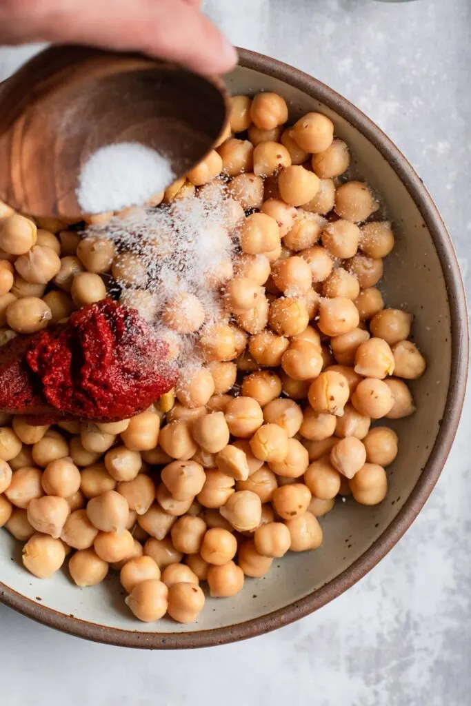 tossing salt onto chickpeas