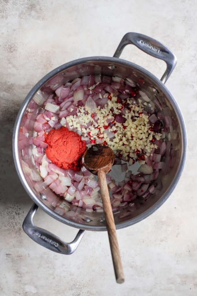 cebollas y ajo salteados en una olla, con polvo de curry recién agregado