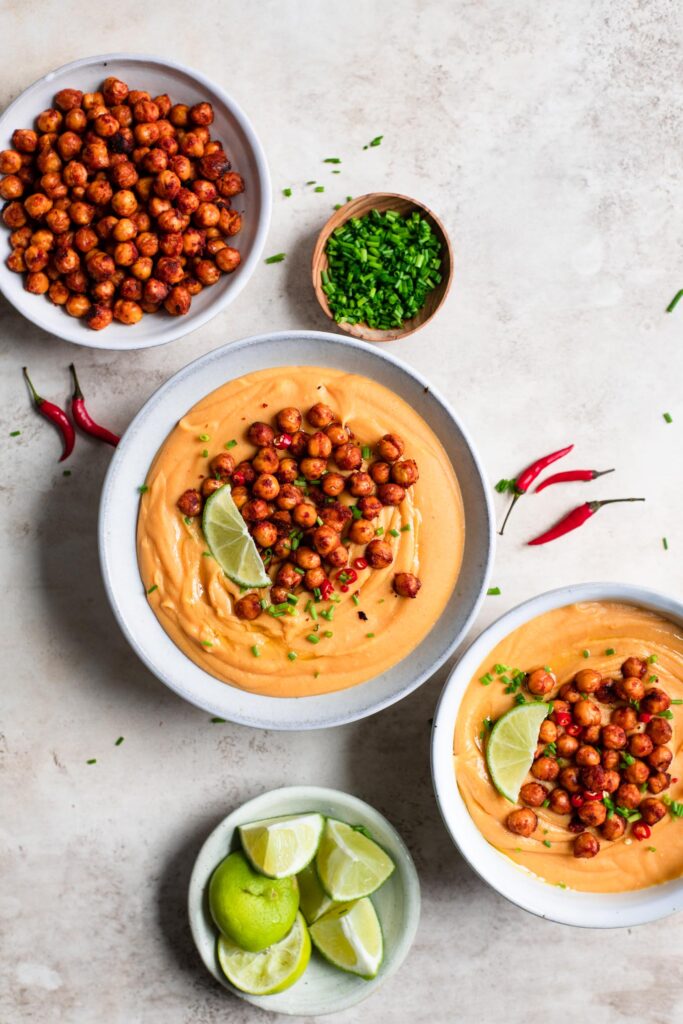 thai red curry lentil soup served with red curry chickpeas, lime wedges, chives, and thai chilies