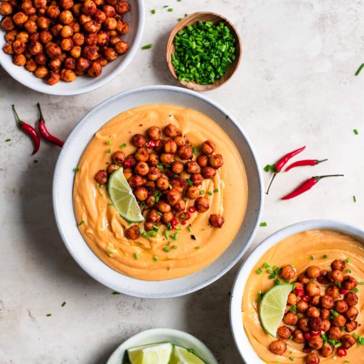 thai red curry lentil soup served with red curry chickpeas, lime wedges, chives, and thai chilies