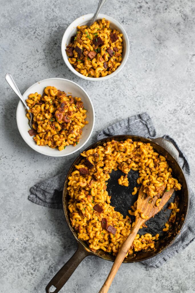 fried bacon mac and cheese served into bowls from cast iron skillet