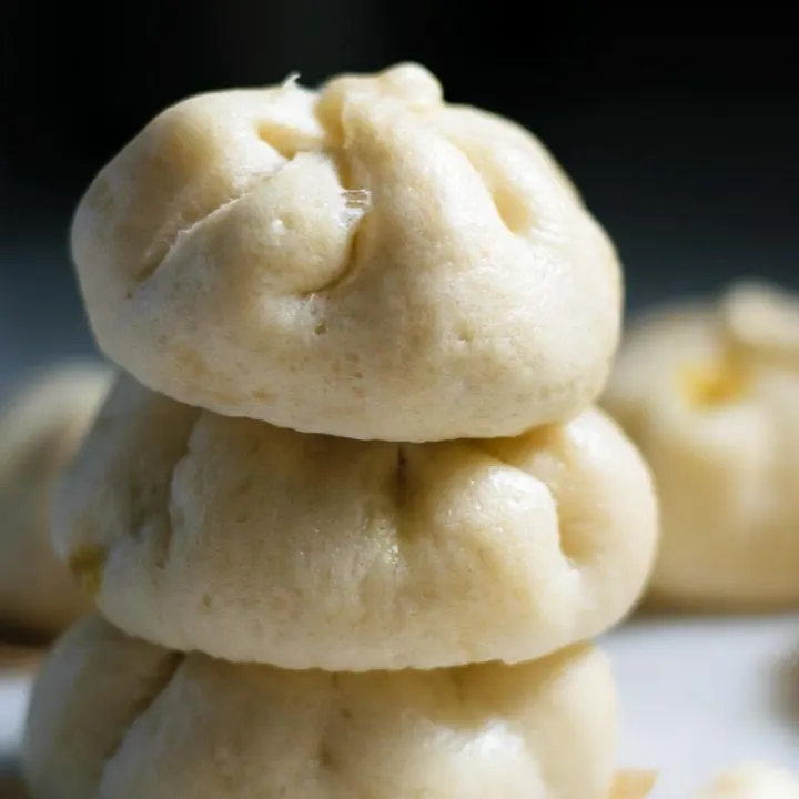 vegan curry seitan steamed buns, stacked 3 high with more in foreground and background