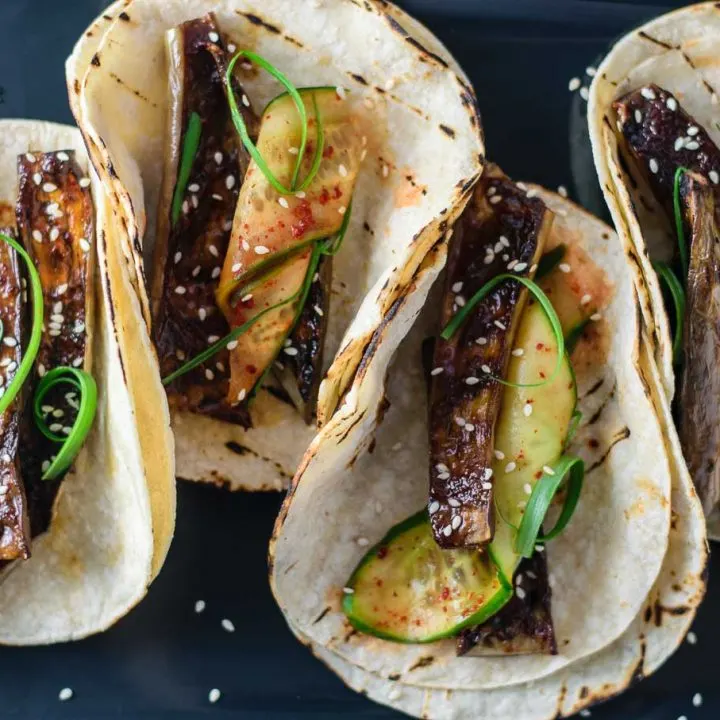 prepared miso-glazed eggplant tacos with marinated cucumbers and scallions