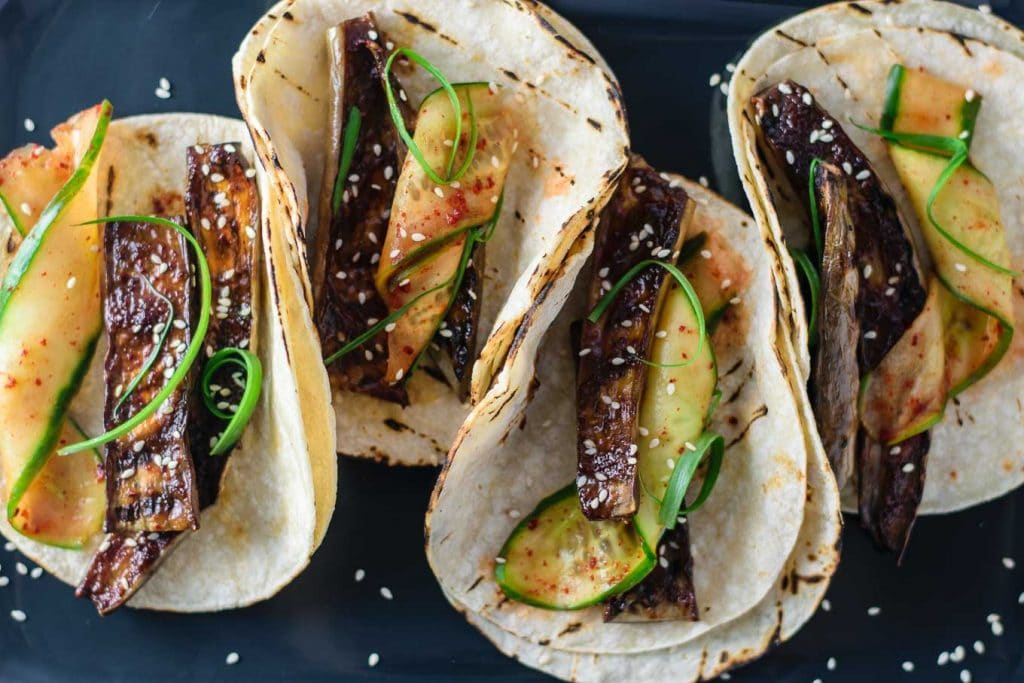 prepared miso-glazed eggplant tacos with marinated cucumbers and scallions