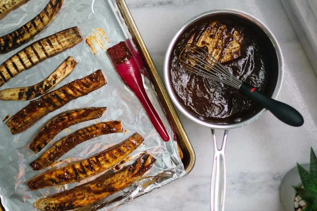 grilled eggplant on foil lined baking tray, with dengaku being brushed on it