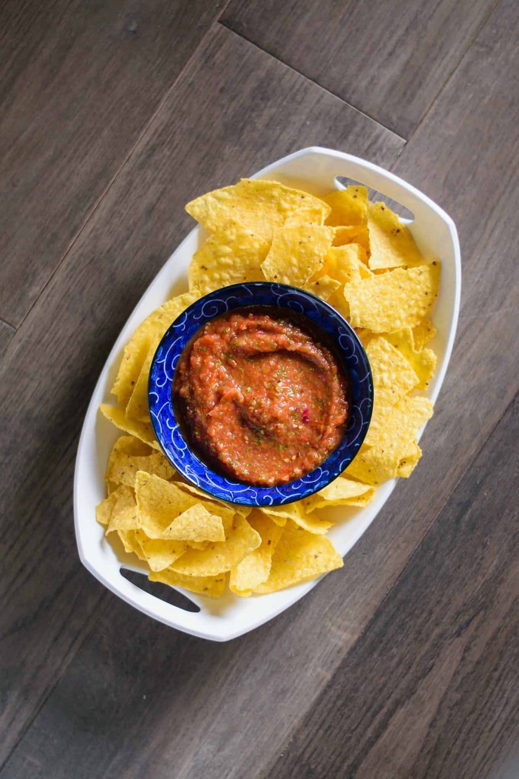 spicy roasted tomato salsa in bowl surrounded with tortilla chips