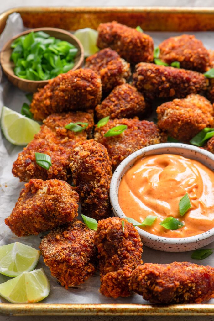 vegan gochujang tempeh wings on a tray with dipping sauce