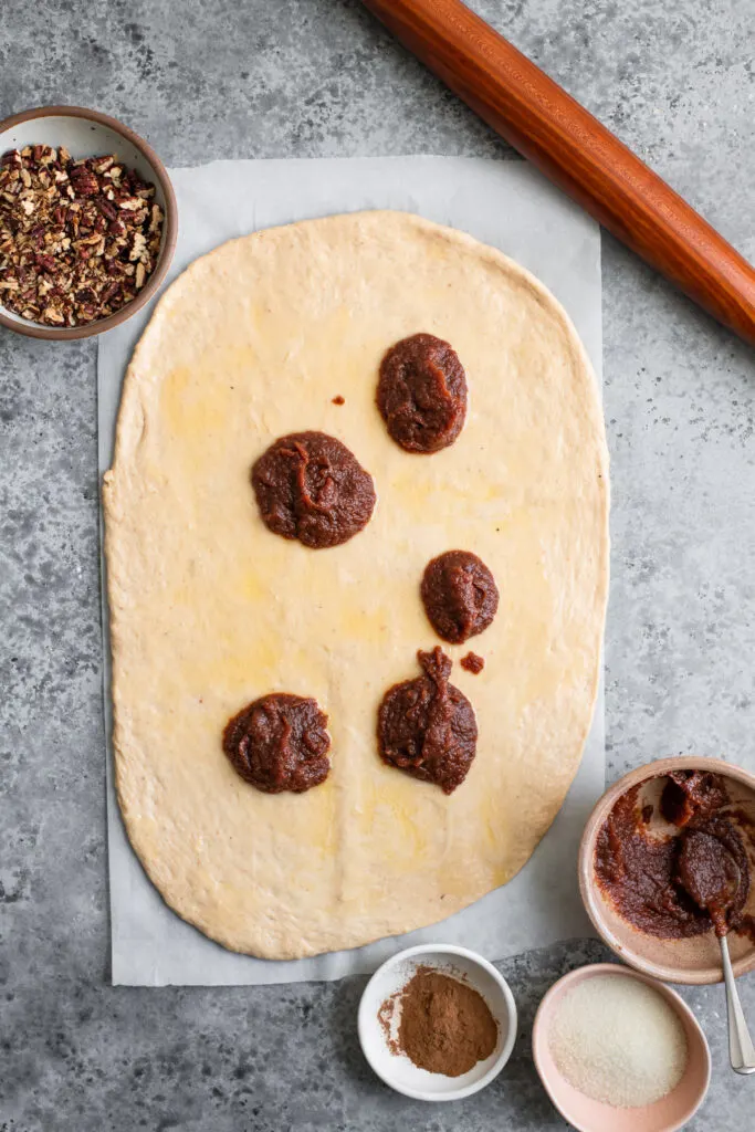 dough spread with vegan butter and dolloped with apple butter