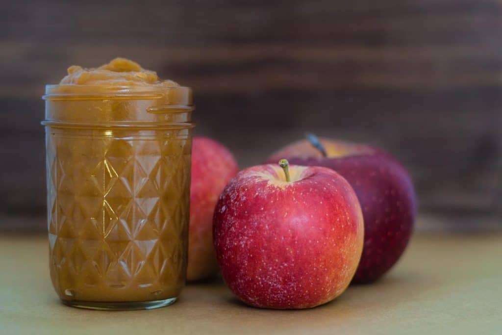 apple butter in jar with apples in background
