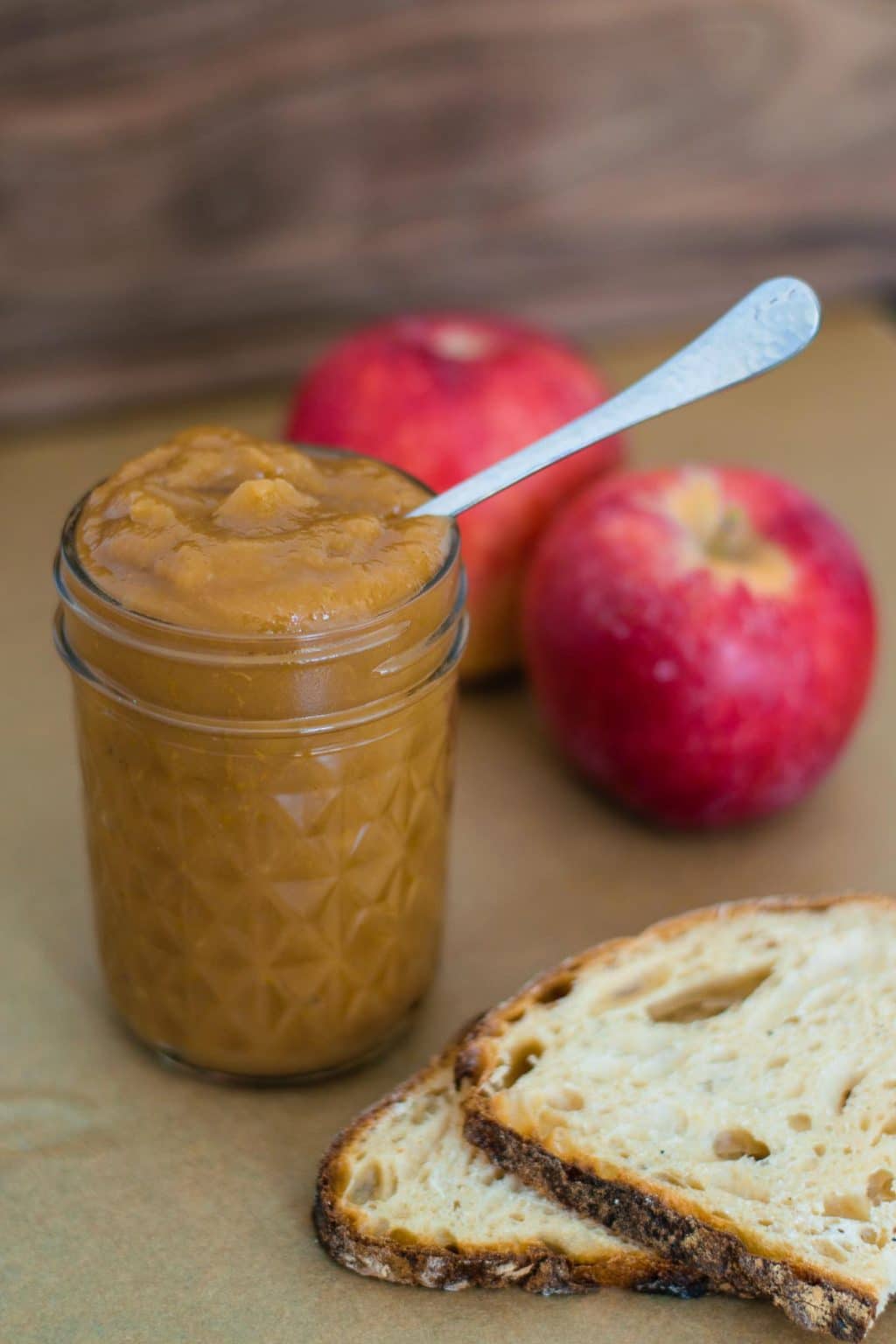 apple butter in jar with apples and slices of bread