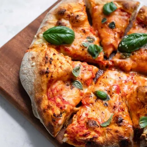 vegan cheese pizza made with easy overnight pizza dough on a cutting board cut into slices