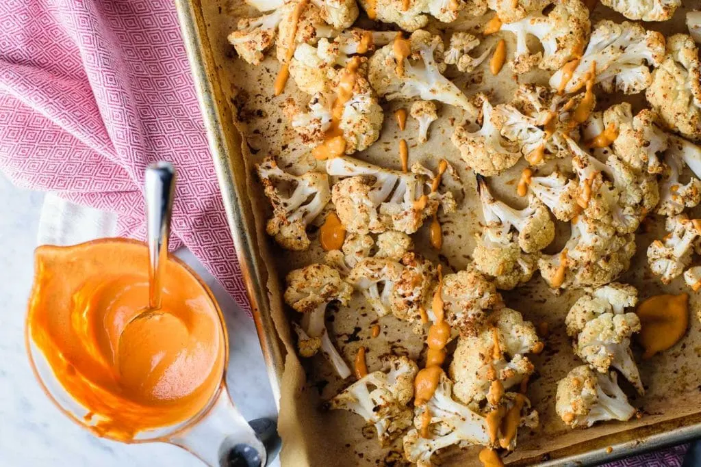 mustard roasted cauliflower with roasted red pepper drizzle