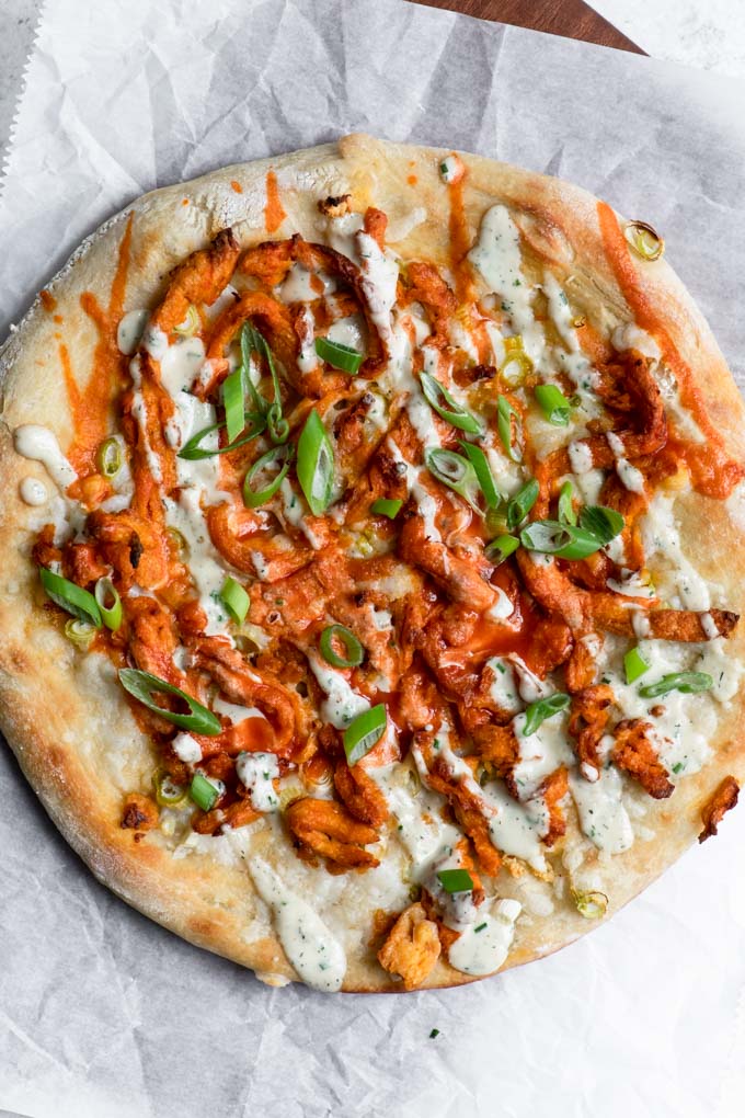 vegan buffalo pizza drizzled with hot sauce and cashew ranch dressing
