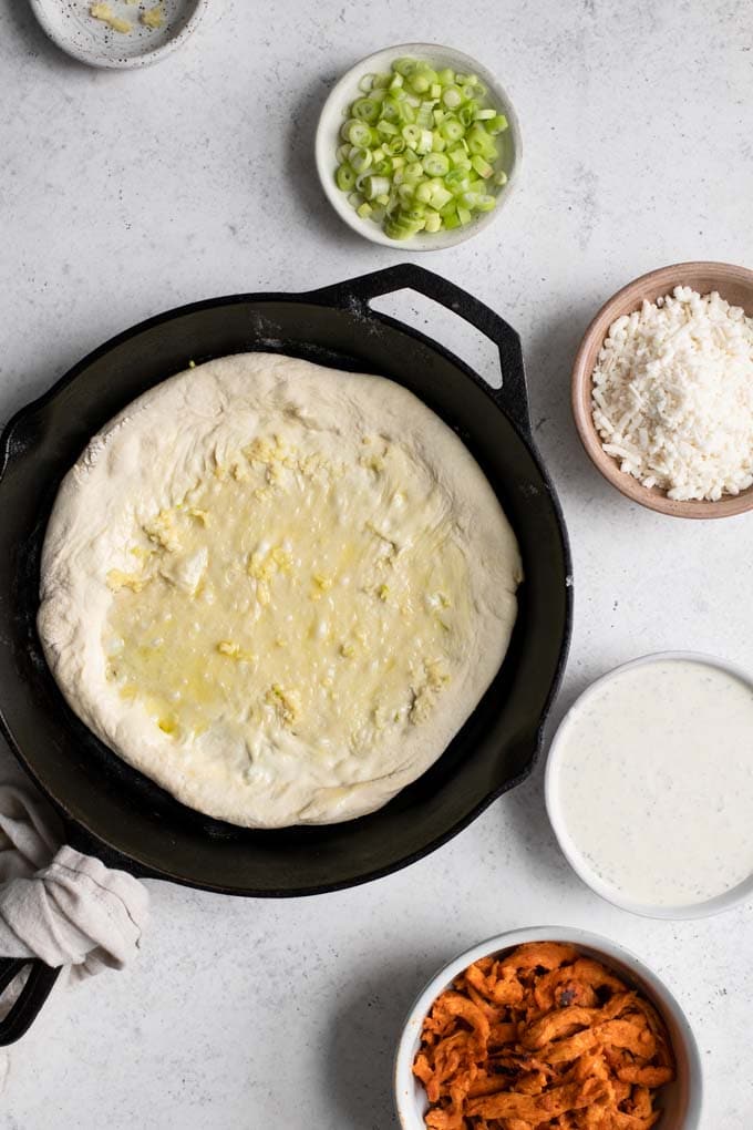 pizza dough topped with olive oil and crushed garlic