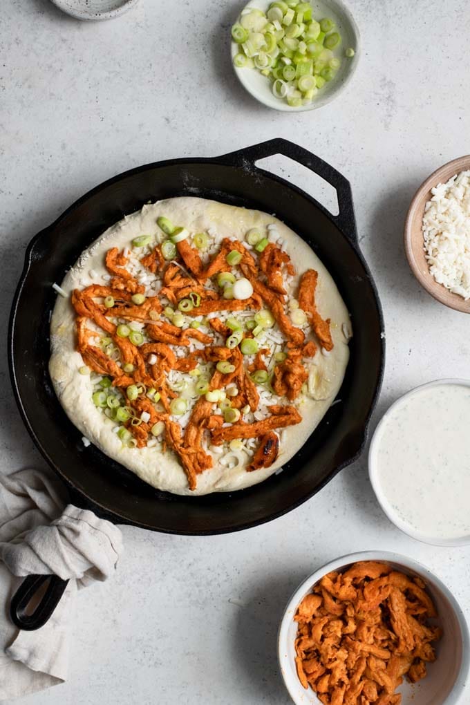 vegan buffalo pizza topped before baking