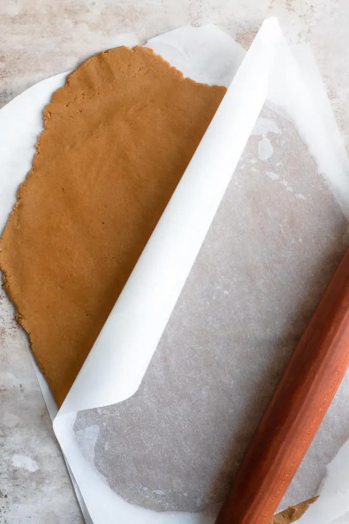 wishing cookie dough rolled out between to sheets of parchment paper