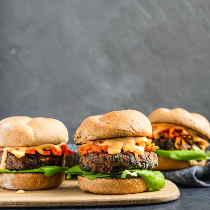 Vegan gochujang bean burgers topped with kimchi, fermented carrots, and gochujang mayo.