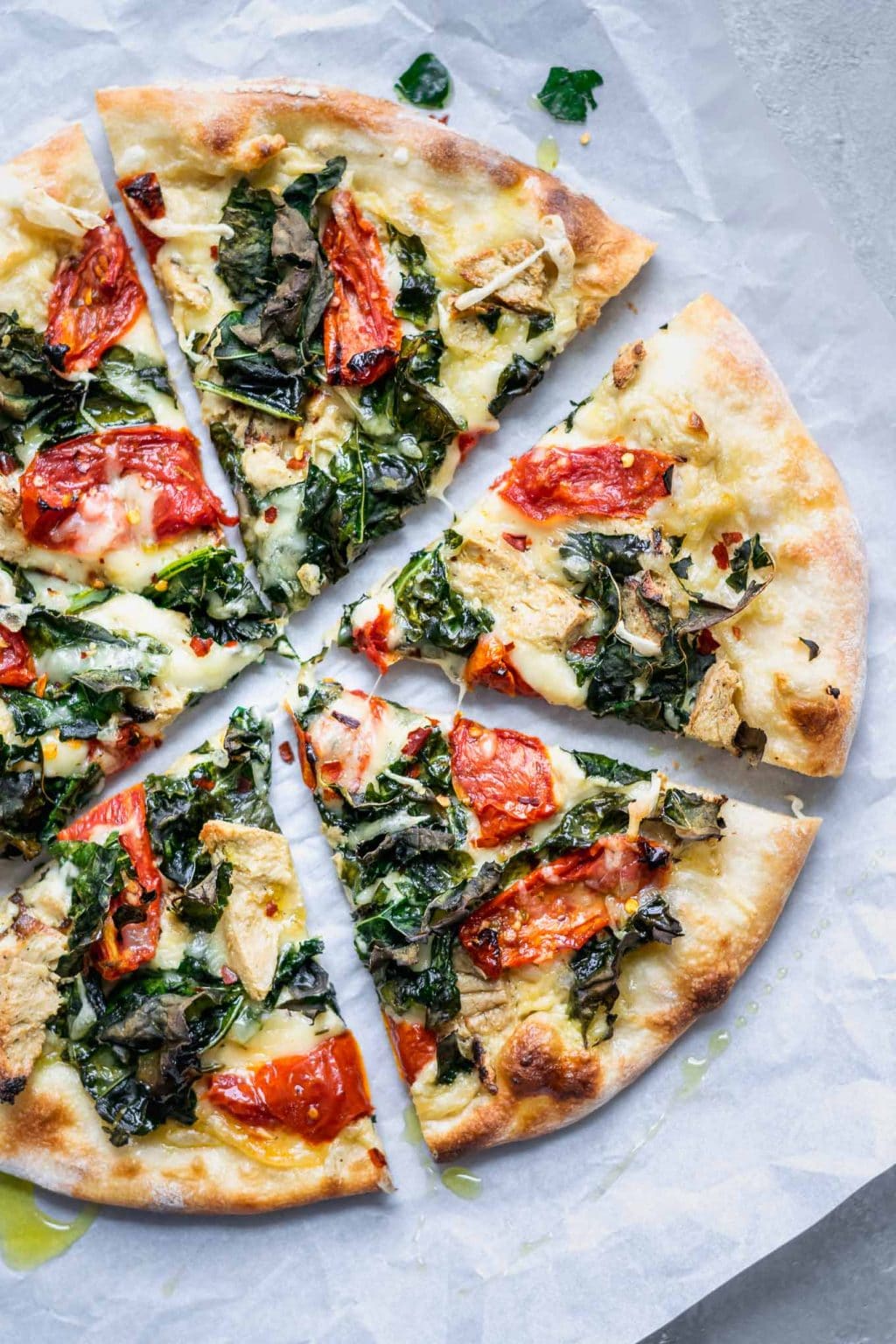 Sliced Crispy Kale, Roasted Tomato, and Vegan Chicken White Sauce Pizza