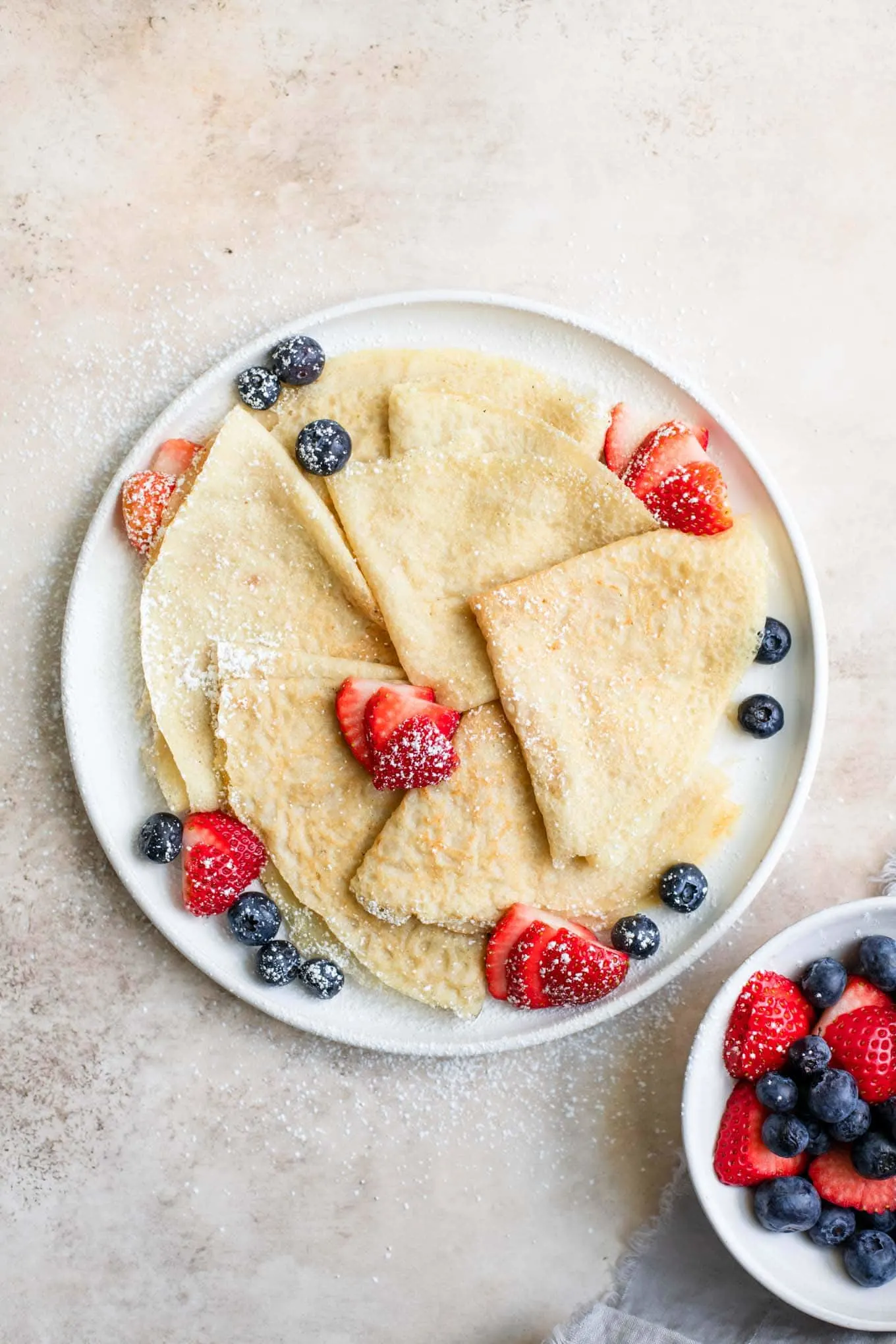 vegan crepes served with fresh fruit and powdered sugar