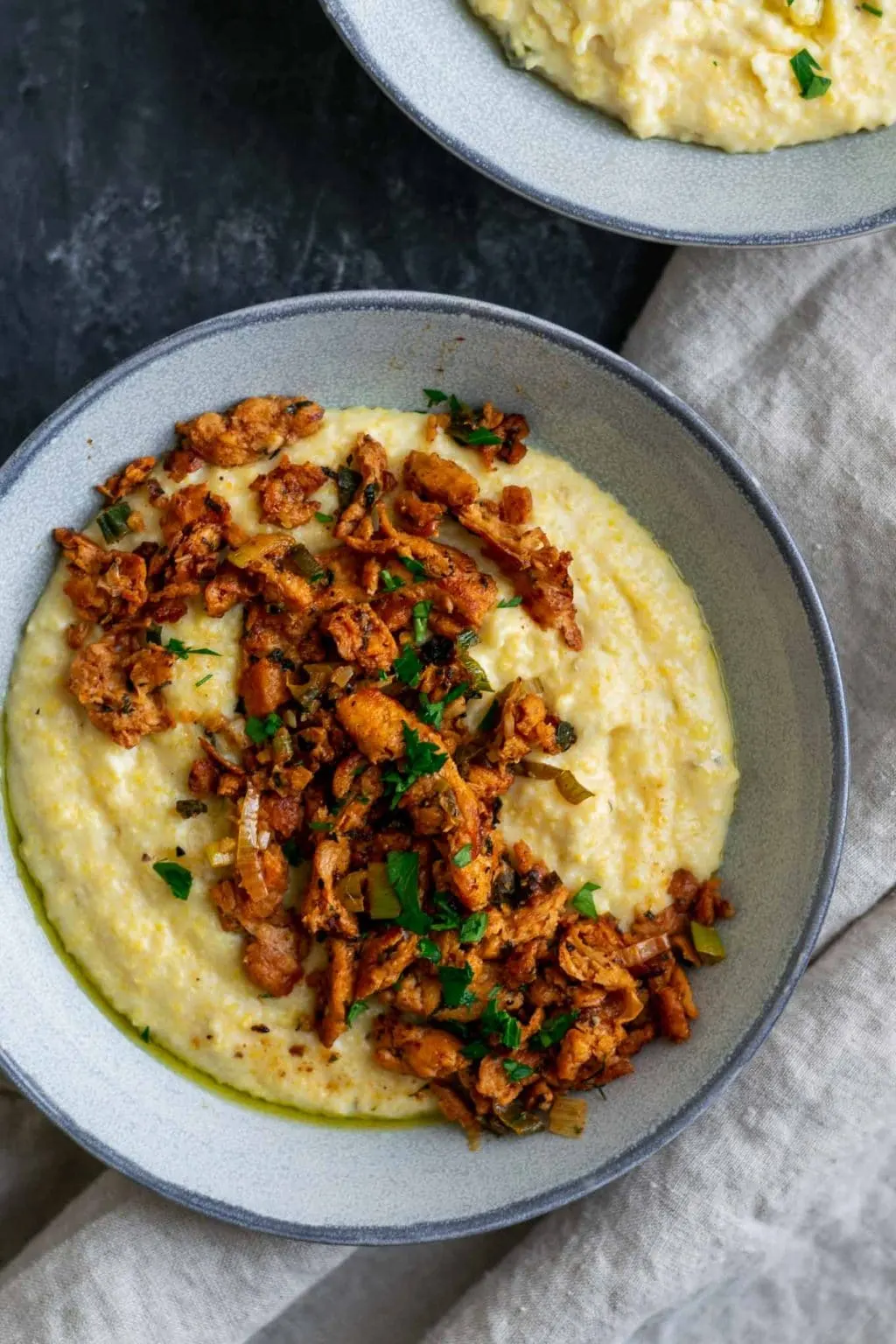 Cajun soy curls and creamy vegan jalapeño grits close up overhead of one bowl