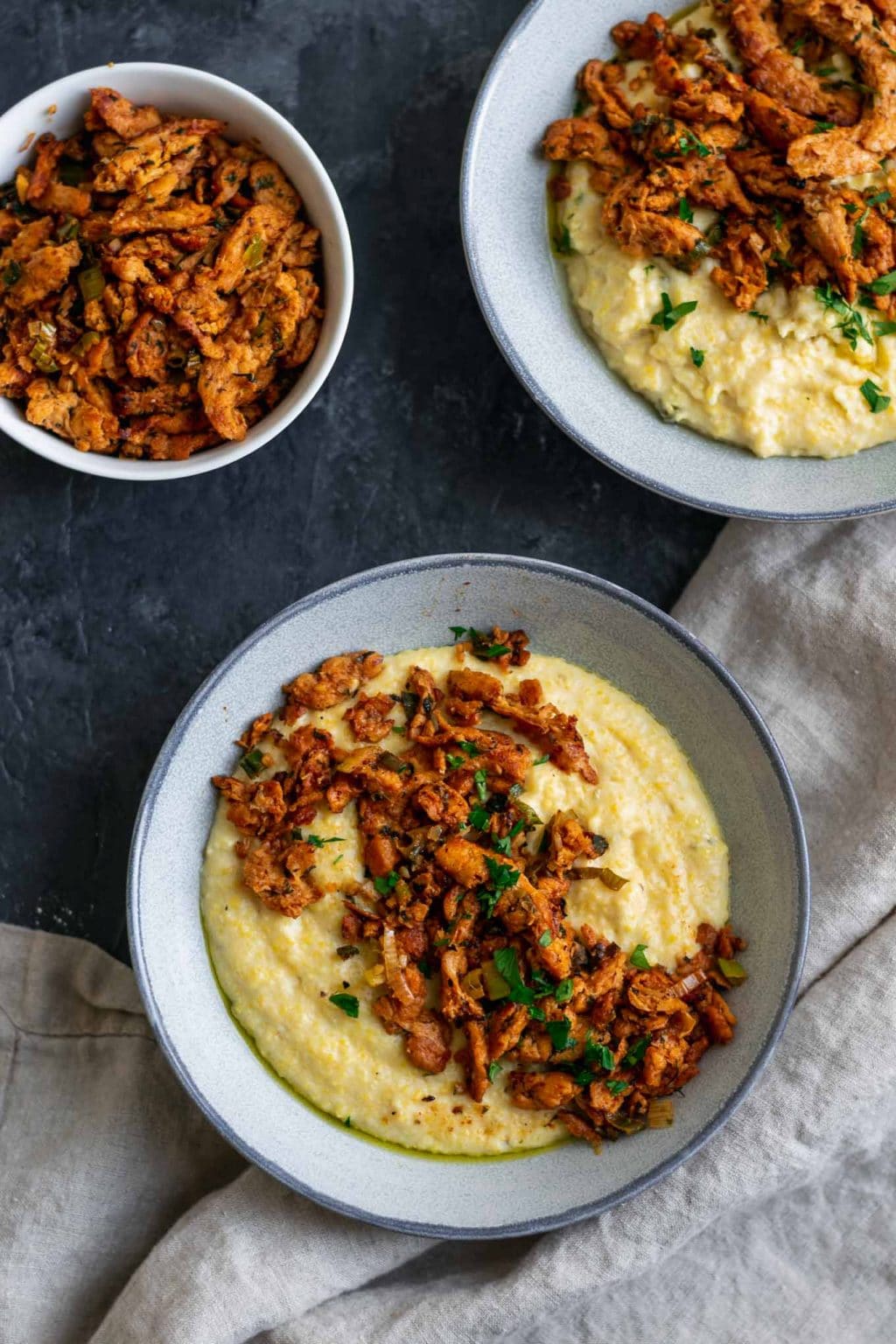 Cajun soy curls and creamy vegan jalapeño grits, two servings with an extra bowl of cajun soy curls