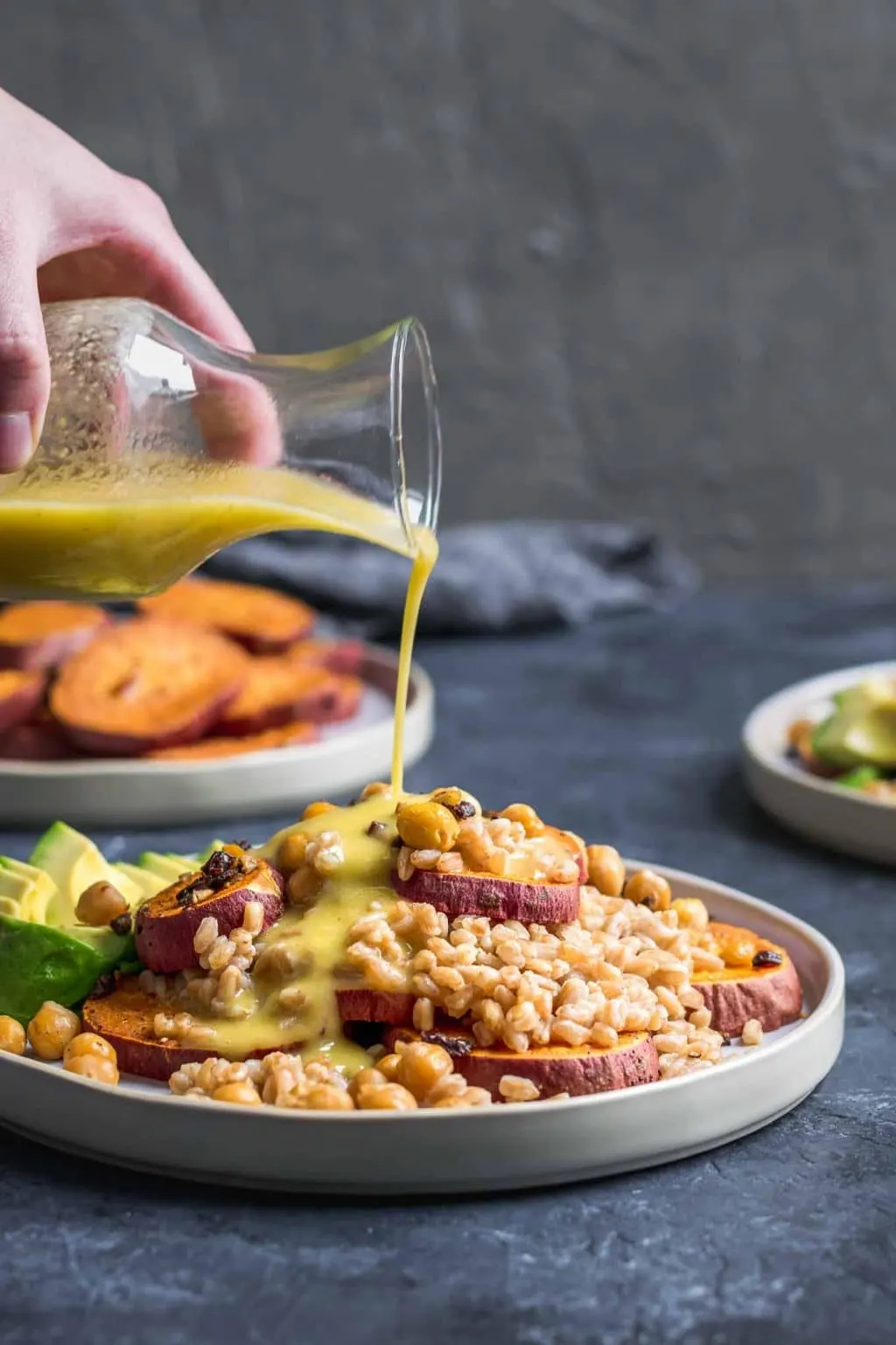 Dressing the roasted sweet pototo and farro salad with garlicky chickpeas