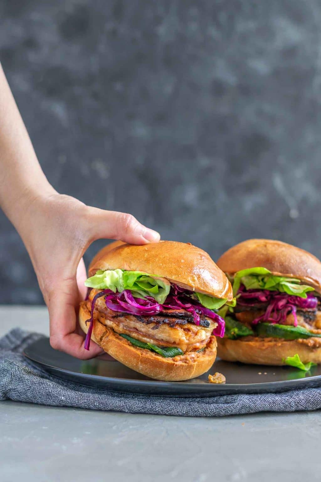 Vegan battered tofu Mexican tortas, grabbing one off a plate