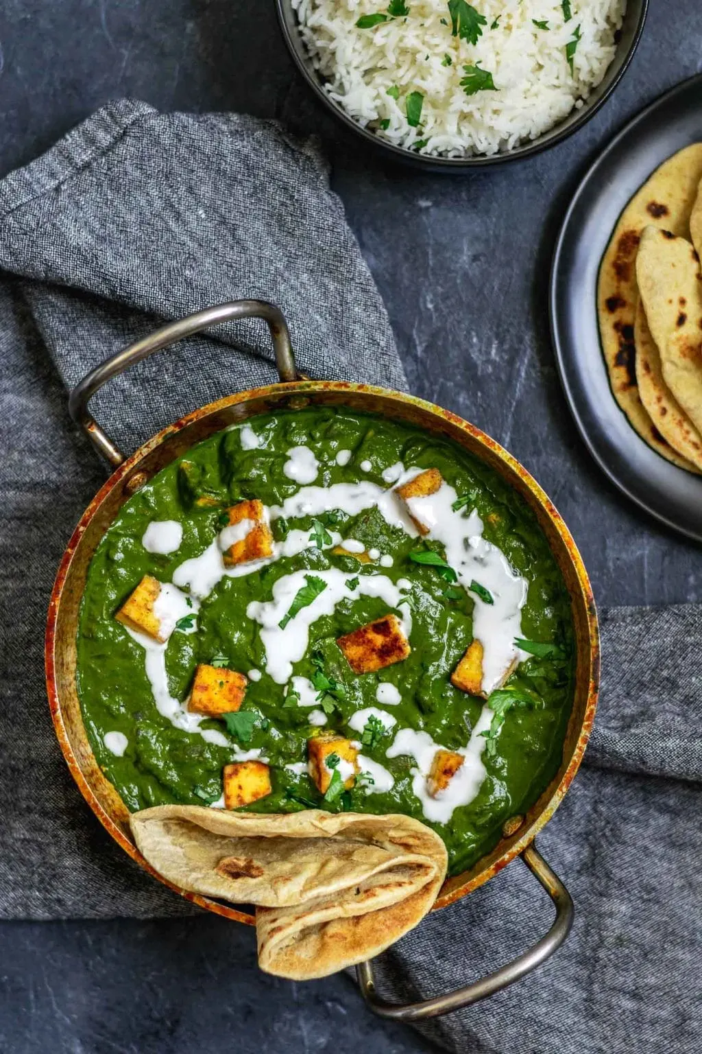 vegan palak tofu paneer with a drizzle of coconut milk and served with fresh chapati bread and basmati rice