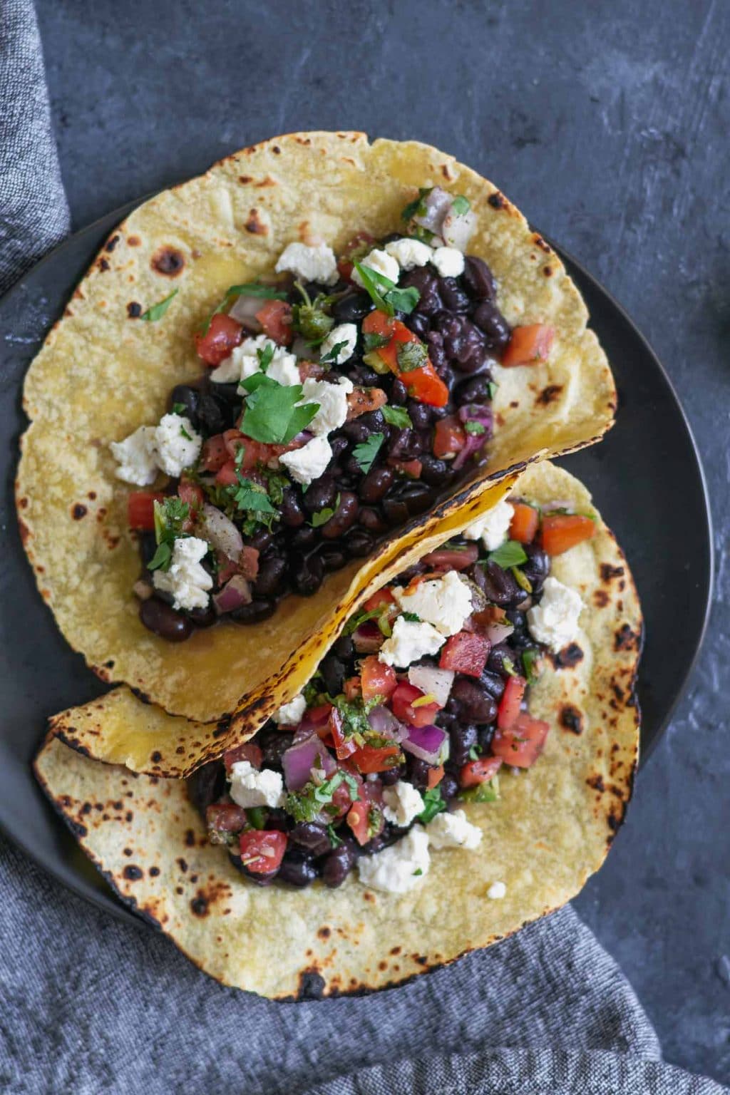 Easy homemade vegan queso fresco on black bean tacos with pico de gallo and charred corn tortillas.