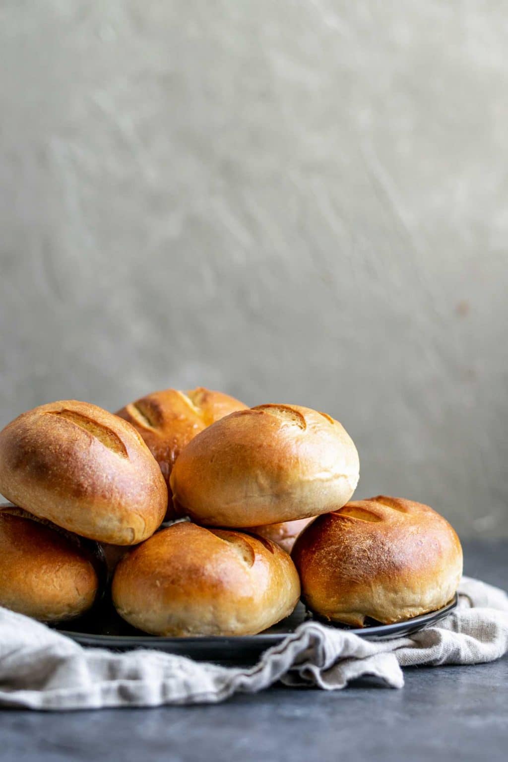 ultimate homemade sandwich rolls stacked on a plate, side view