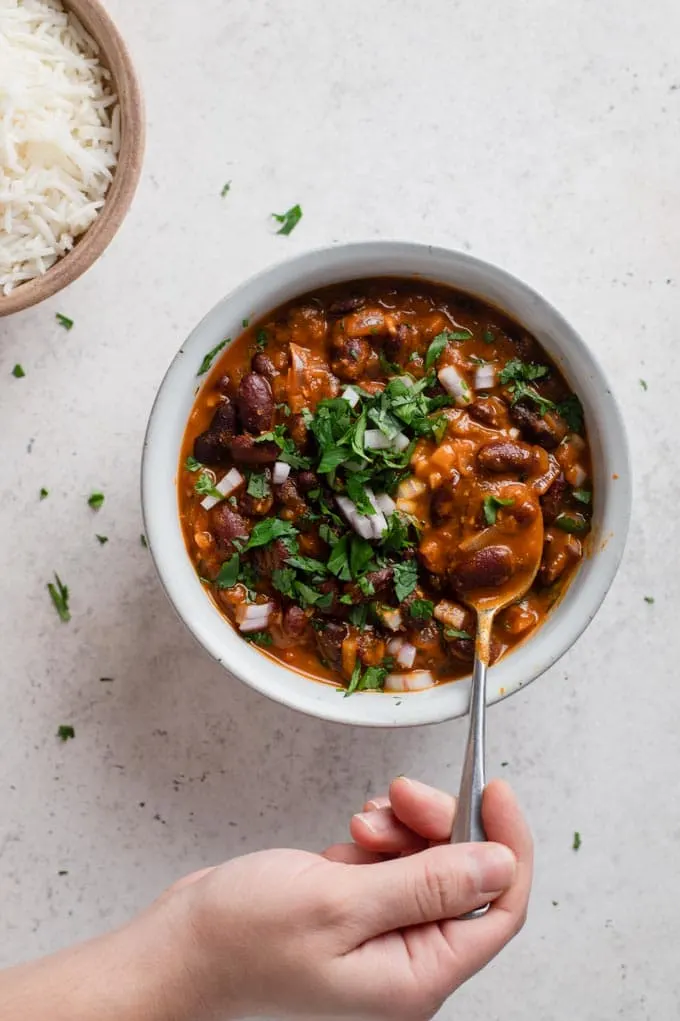 someone having a spoonful of afghan kidney bean curry