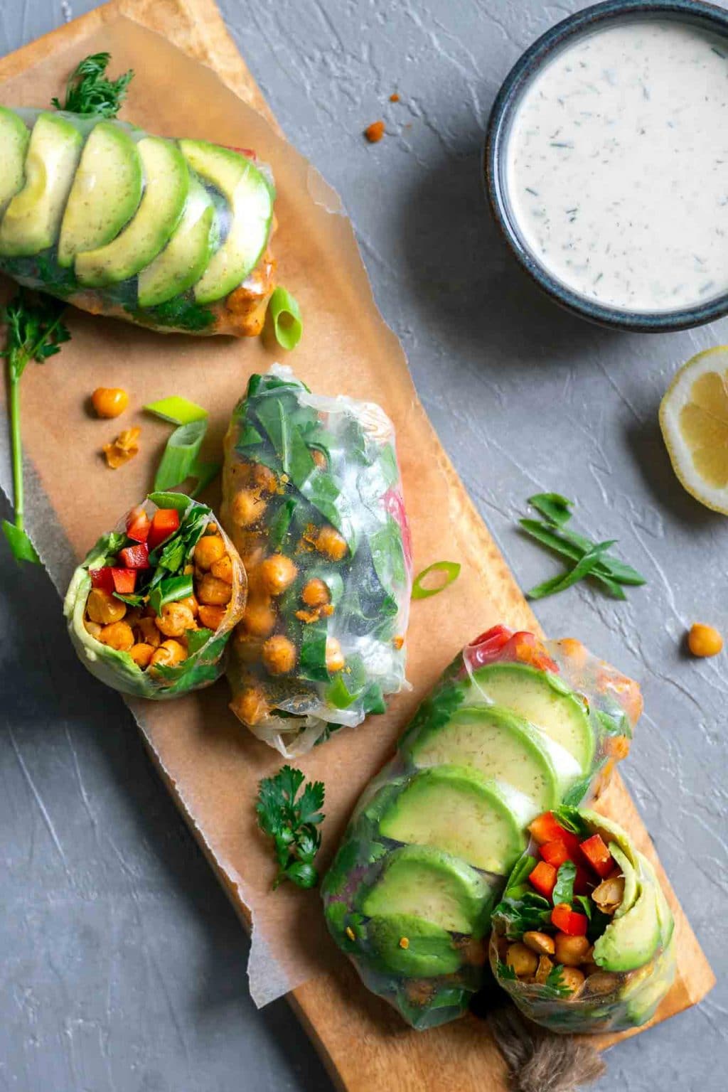 Buffalo chickpea rice paper wraps with tahini ranch dip served on a wooden board with dip in a bowl