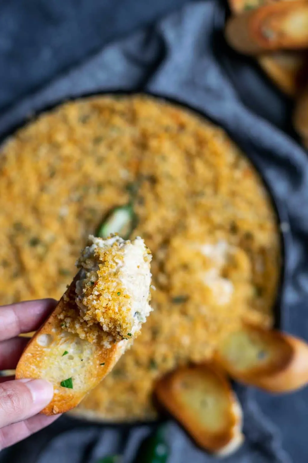 A scoop of vegan jalapeño popper dip on a crostini