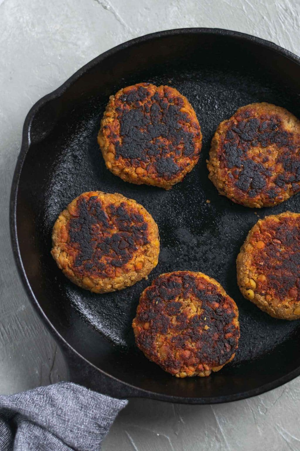 vegan tempeh maple breakfast sausage patties on a cast iron skillet