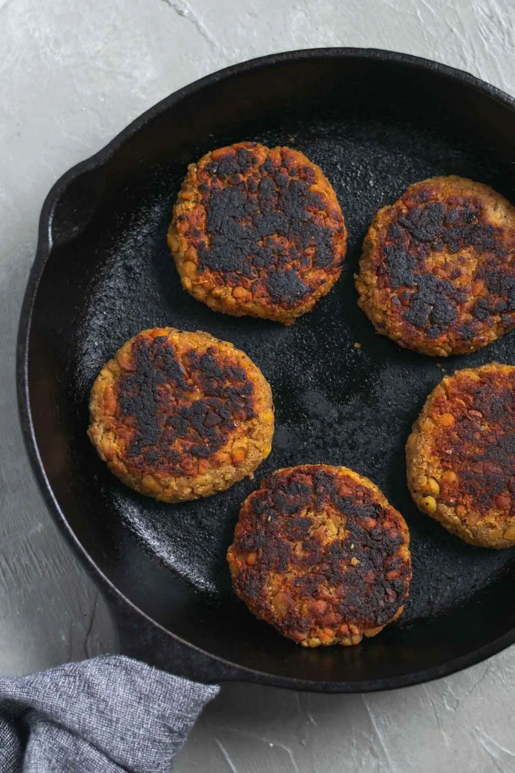 vegan tempeh maple breakfast sausage patties on a cast iron skillet