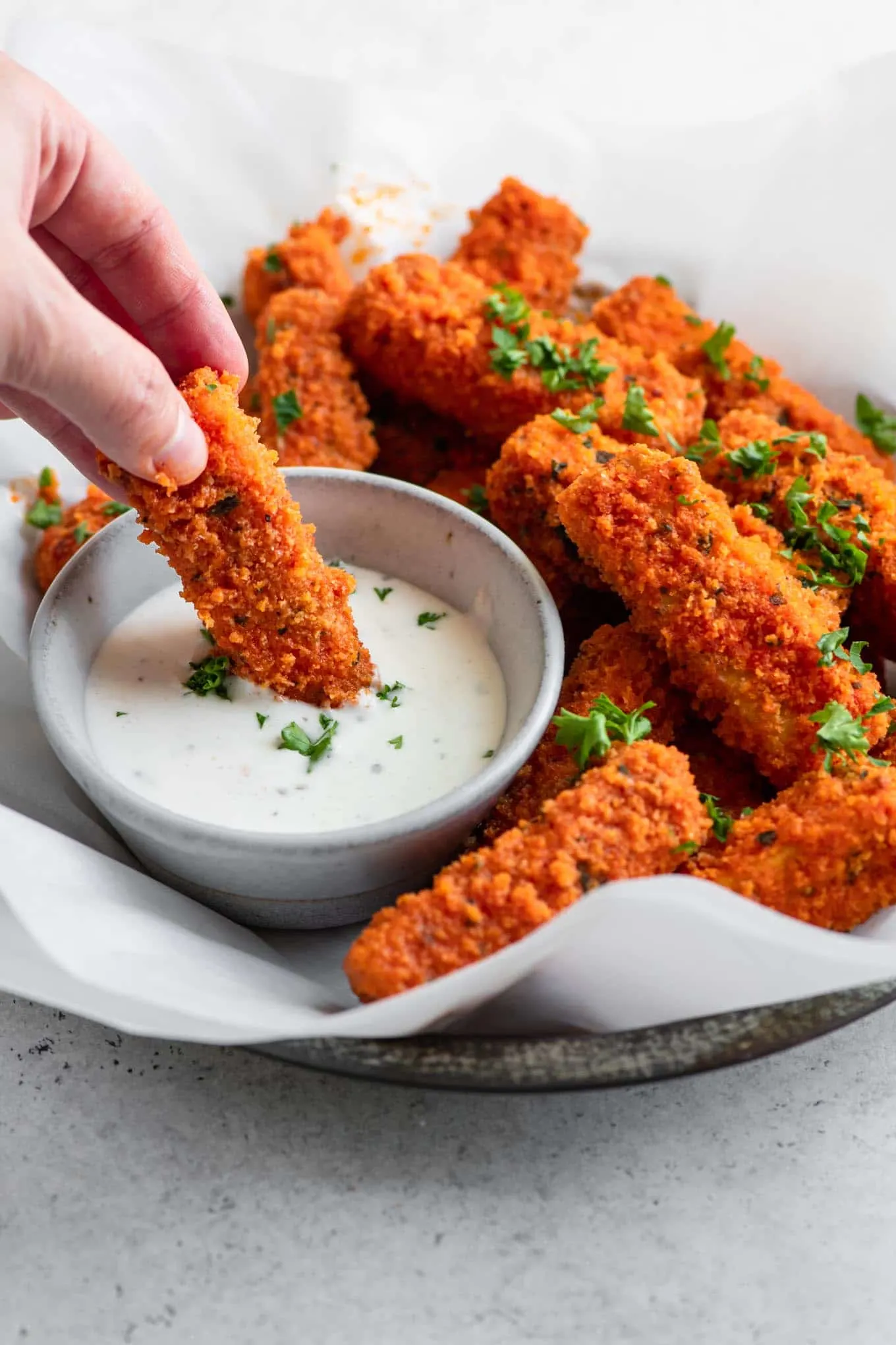 dipping buffalo tofu into dressing