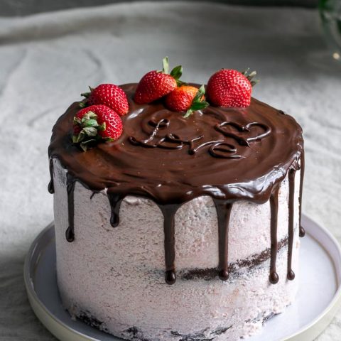 Chocolate cake with vegan aquafaba strawberry Italian meringue buttercream and a chocolate drip