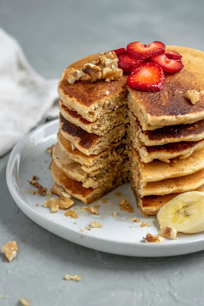 Make ahead whole grain cornmeal vegan pancake mix cooked and stacked 6 tall with a wedge cut open for a bite