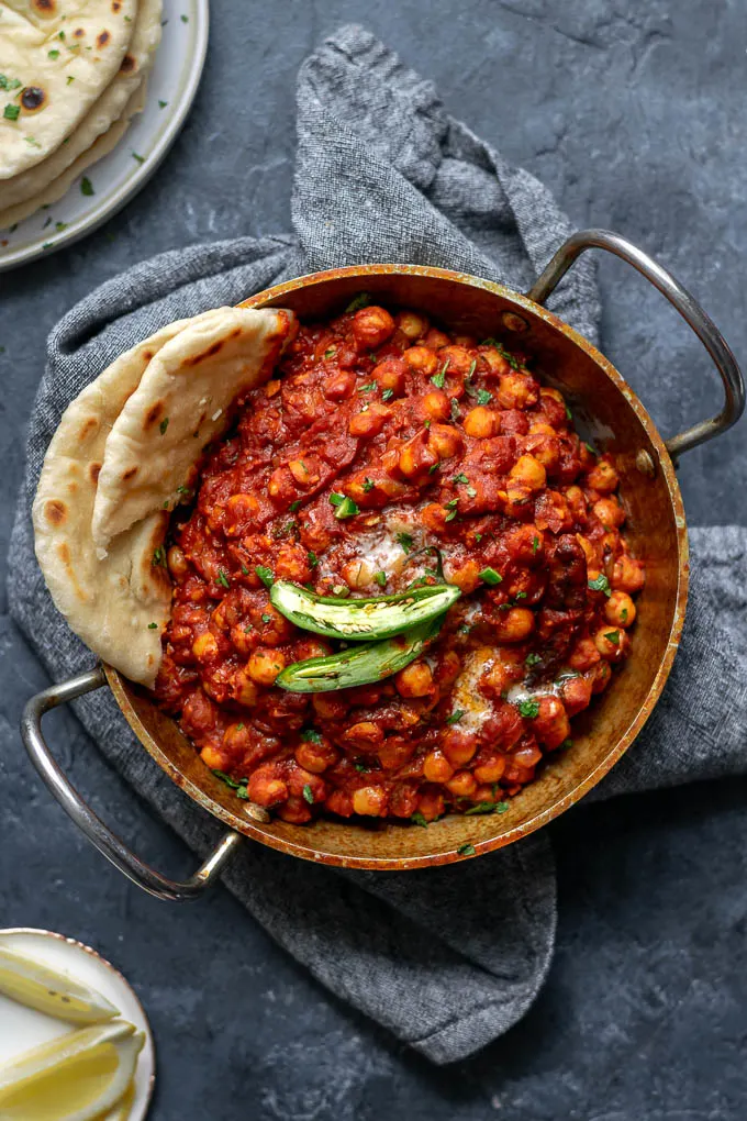 Restaurant style chana masala served with garlic naan and green chiles