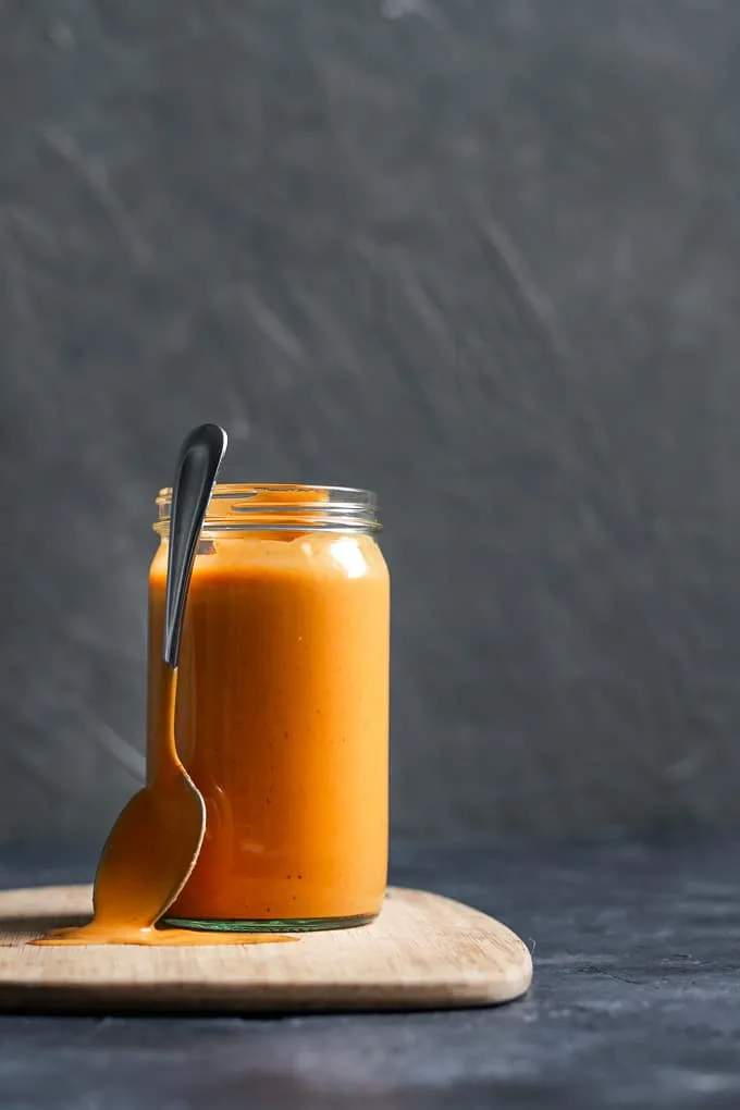 Creamy Mexican chipotle sauce made with aquafaba served in a glass jar with a spoon to serve