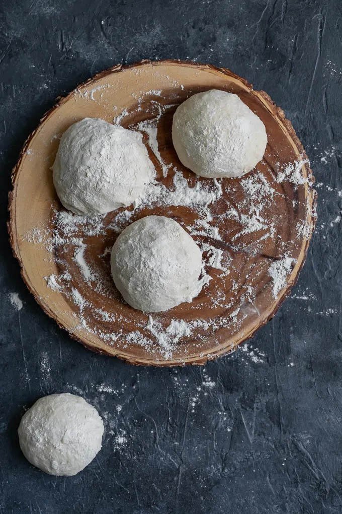 naan dough shaped into balls for the second rise