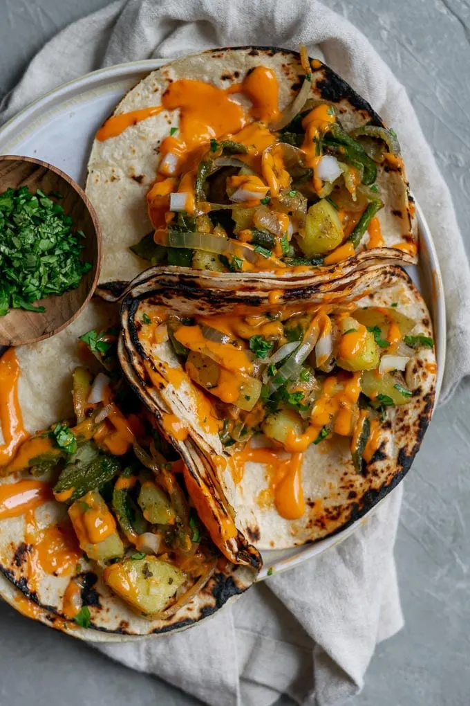 Paps rajas tacos (potato and roasted poblano tacos) with a drizzle of creamy Mexican chipotle sauce