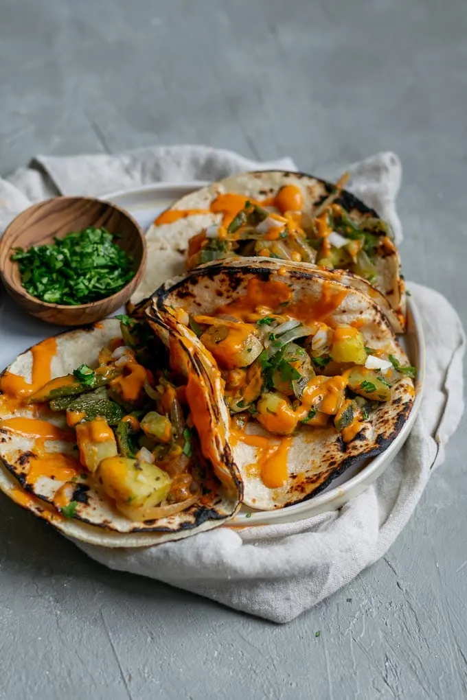 Paps rajas tacos (potato and roasted poblano tacos) with a drizzle of creamy Mexican chipotle sauce