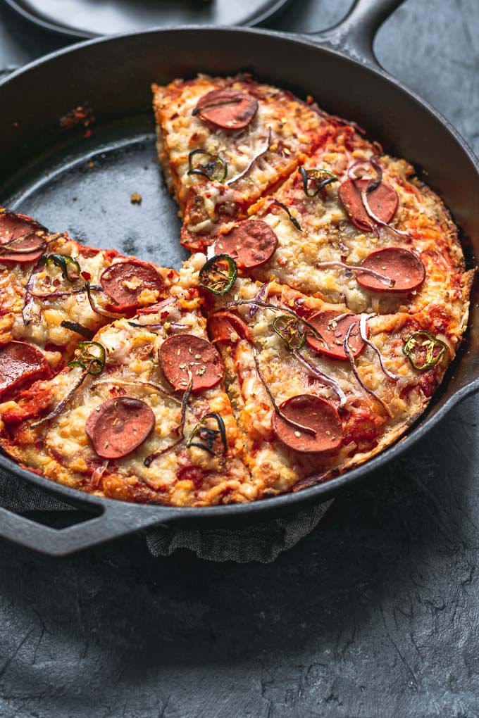 angled view of vegan pepperoni pan pizza in cast iron skillet